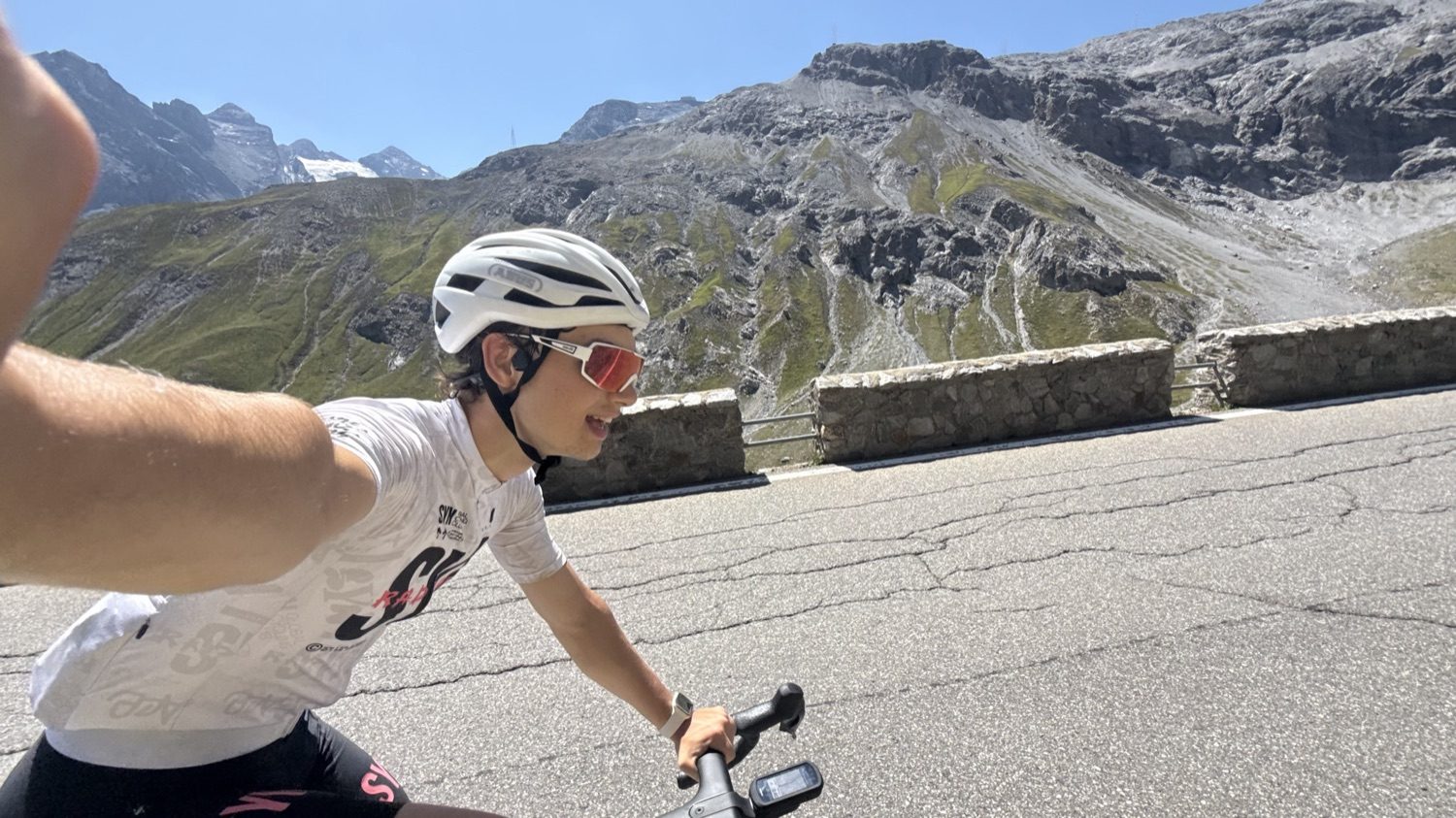 A selfie riding a mountain road, rocky peaks behind