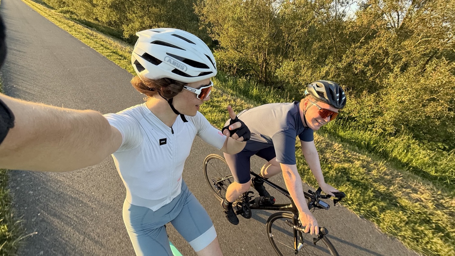 A fist bump between two riders on a sunny road